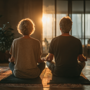 Чоловік та жінка зрілого віку виконують вправи йоги на природі